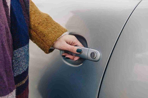 Technician unlocking a car door using professional lockout tools during a roadside vehicle lockout service