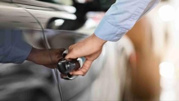Close-up of a hand pulling a car door handle during a vehicle lockout situation